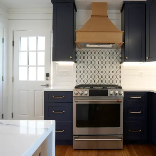 Navy kitchen cabinets with wood range hood